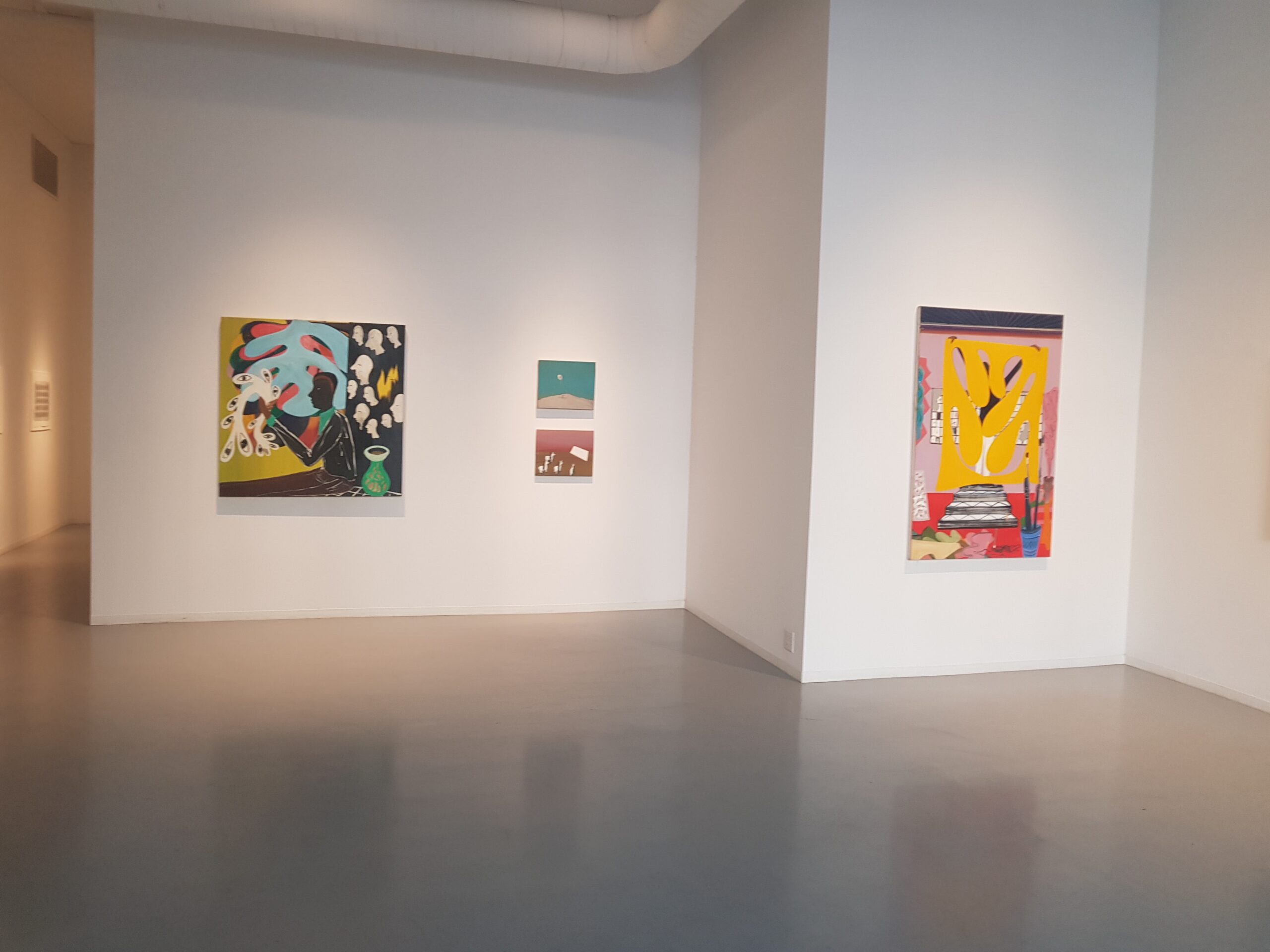 three paintings on a wall in an Exhibition