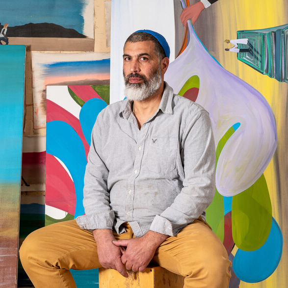 man sitting on a chair with colourful background